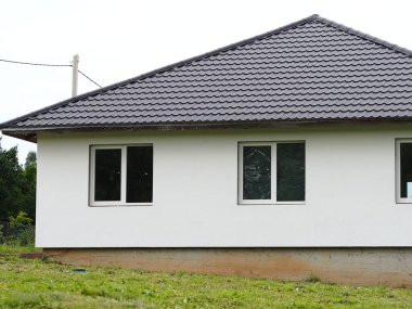 Modern bir inşaat penceresi ve çatısında yeni bir evin duvarını inşa etmek