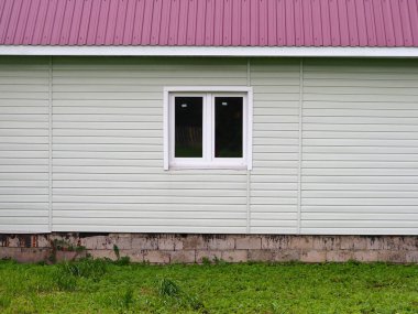 Modern bir inşaat penceresi ve çatısında yeni bir evin duvarını inşa etmek