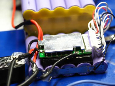 .Belarus, Minsk, 2022 Mobiletin pili bir atölye ustası tarafından tamir ediliyor.