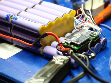 .Belarus, Minsk, 2022 Mobiletin pili bir atölye ustası tarafından tamir ediliyor.