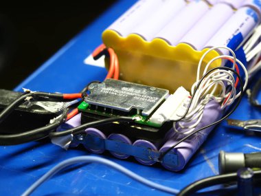 .Belarus, Minsk, 2022 Mobiletin pili bir atölye ustası tarafından tamir ediliyor.