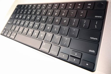 Belarus, Minsk, 2022 MacBook Pro 2021 'in sorunlu klavyesine yapışmış bir insan eliyle bir bez parçasıyla silinmiş.