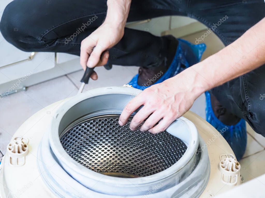 master services man disassembles into a washing machine  repair