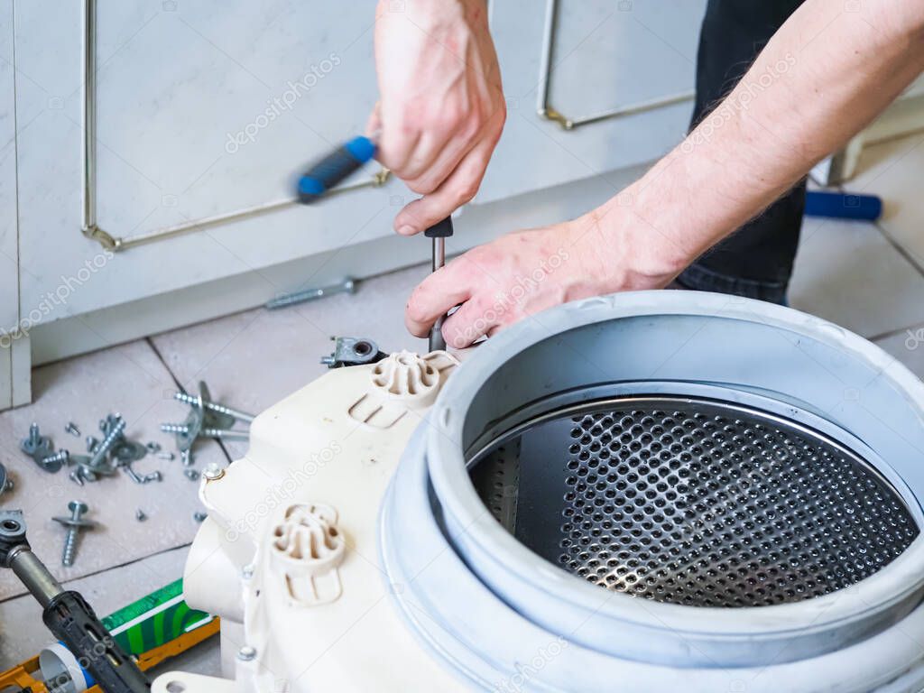 master services man disassembles into a washing machine  repair