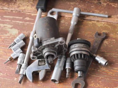 Scooter başlatıcısı masadaki parçaları ve araçları tamir eder