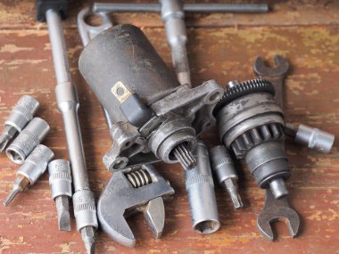 Scooter başlatıcısı masadaki parçaları ve araçları tamir eder