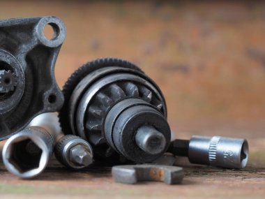 Scooter başlatıcısı masadaki parçaları ve araçları tamir eder