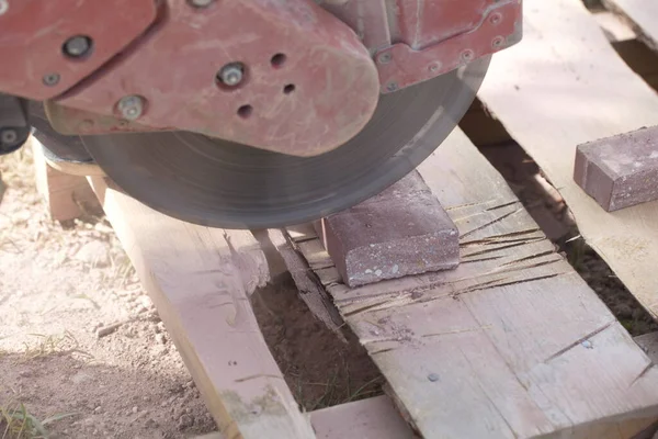 建設労働者は 電力カットでコンクリートタイルレンガを切断します — ストック写真