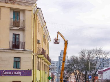 Beyaz Rusya, Minsk, 2022. Hidrolik asansörde çalışan bir işçi buz saçaklarını bir evin çatısından düşürdü..