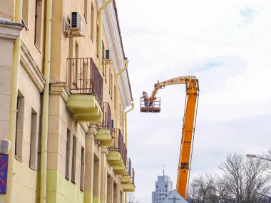 Beyaz Rusya, Minsk, 2022. Hidrolik asansörde çalışan bir işçi buz saçaklarını bir evin çatısından düşürdü..