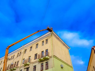 Beyaz Rusya, Minsk, 2022. Hidrolik asansörde çalışan bir işçi buz saçaklarını bir evin çatısından düşürdü..