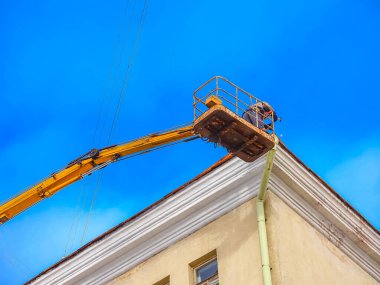 Beyaz Rusya, Minsk, 2022. Hidrolik asansörde çalışan bir işçi buz saçaklarını bir evin çatısından düşürdü..