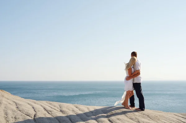 Fille et garçon debout bras dans le bras près de la mer — Photo