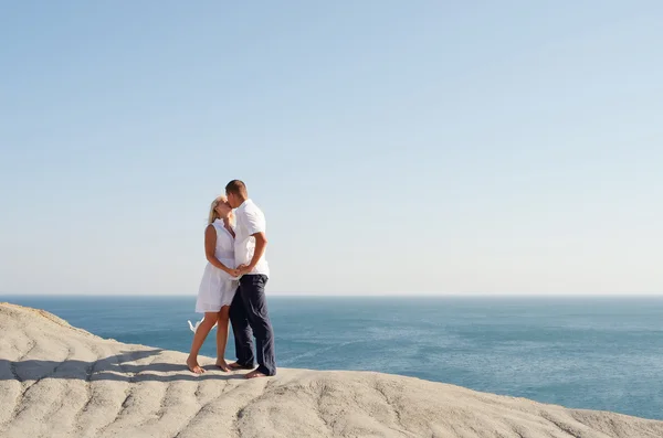 同时站在一块岩石上亲吻的年轻夫妇 — 图库照片