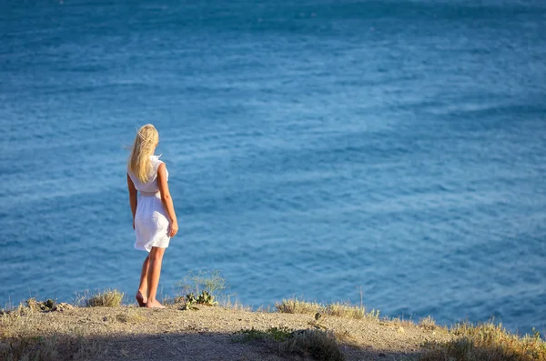 Joven chica de pie en la playa — Foto de Stock