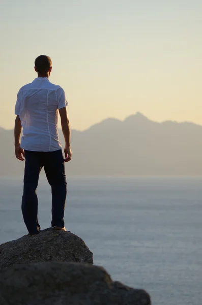 Man stands on a rock — Stock Photo, Image