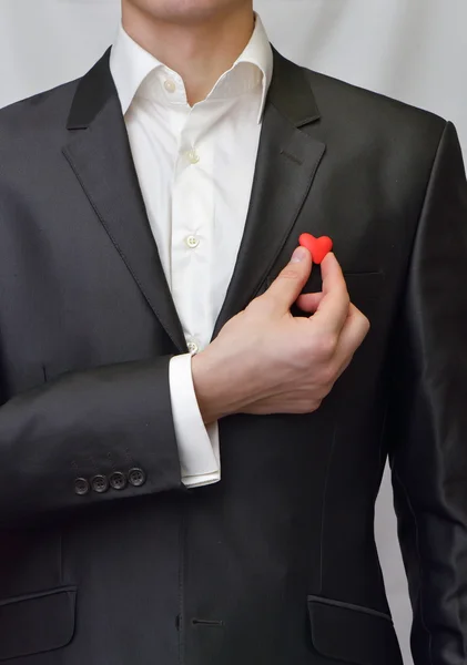 Ein Mann im Anzug mit einem dekorativen Herzen in der Hand — Stockfoto