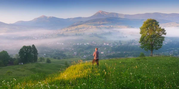 Jovem apreciando o nascer do sol na aldeia da montanha — Fotografia de Stock