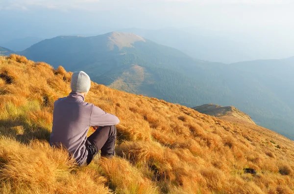 Man sits on a hillside — Stockfoto