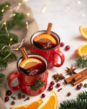 Noel ağacının yanındaki kırmızı bardakta sıcak şarap ve ışıklar.