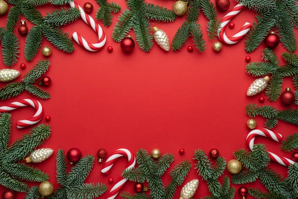 モミの枝や木の装飾で作られた装飾フレームと赤いクリスマスの背景 テキストのフラットレイアウト トップビュー コピースペース — ストック写真