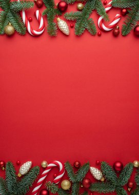 Kırmızı arka plan, köknar dalları ve Noel balolarından yapılmış Noel süslemeleri. Metin için kopyalama alanı olan boşluk