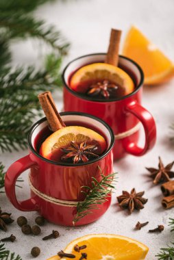 Noel masasında kırmızı bardaklarda sıcak şarap.