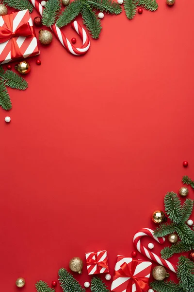 赤い背景にモミの装飾や贈り物とテキストのためのクリスマスフレーム付きのカード — ストック写真