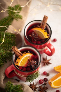 Şenlikli bir Noel masasında kırmızı bardaklarda sıcak şarap.