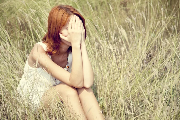 Triste chica pelirroja en la hierba . —  Fotos de Stock