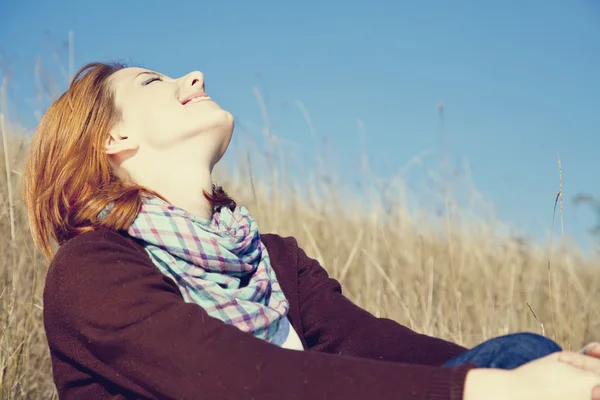 Portrait of happy red-haired girl on autumn grass. — Stock Photo, Image