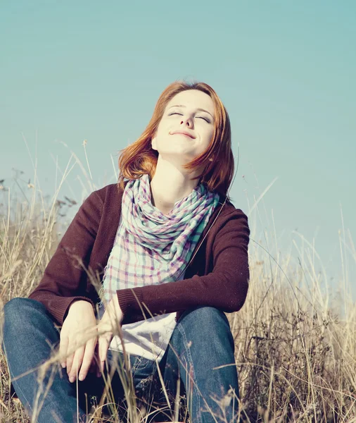 Портрет счастливой рыжей девушки на осенней траве . — стоковое фото