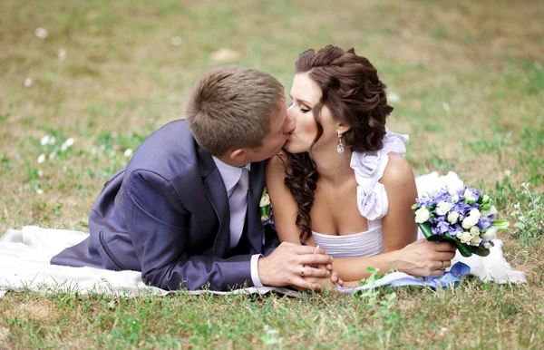 Ungt par brudgummen och bruden kyssar. — Stockfoto