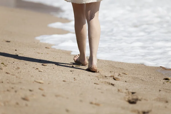 Beskuren bild av en ung kvinna som går på en strand — Stockfoto