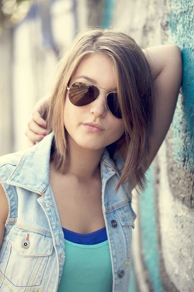 Teenager mit Sonnenbrille in der Nähe von Graffiti-Wand. — Stockfoto