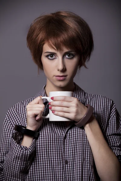 Stijl meisje in shirt met cup op studio. — Stockfoto