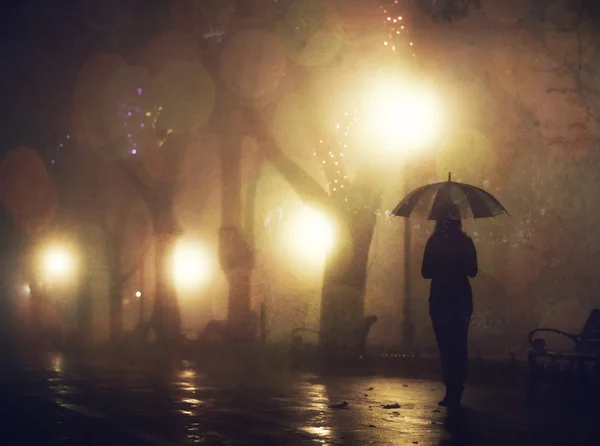 Одна дівчина з парасолькою на нічній алеї. Фото з шумом . — стокове фото