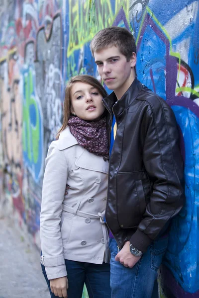 Jeune couple près de fond de graffiti . — Photo