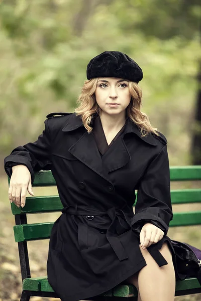 Style redhead girl sitting at bench in autumn park. — Stock Photo, Image