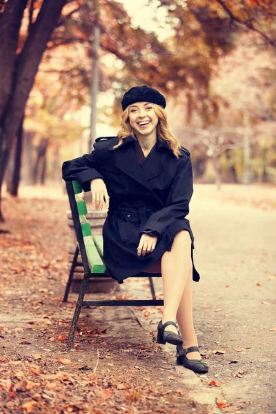 Chica pelirroja estilo sentado en el banco en el parque de otoño . — Foto de Stock