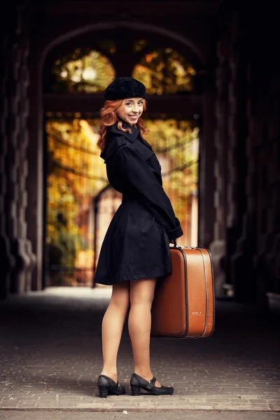 Rödhårig tjej med väska på hösten gatan. — Stockfoto