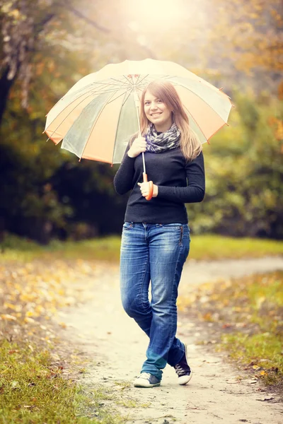 Mooi meisje met paraplu in herfst park. — Stockfoto