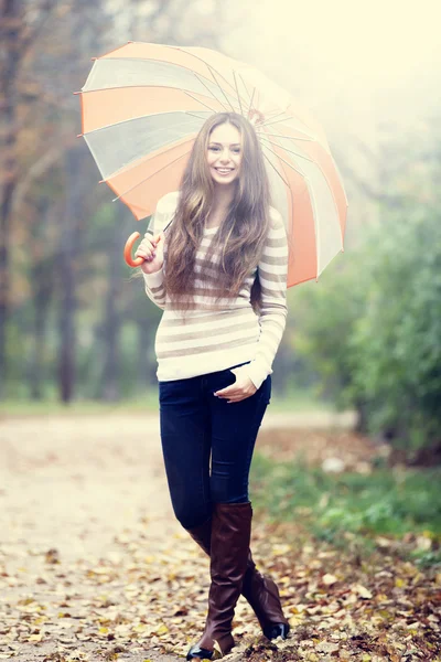 Menina bonita com guarda-chuva no parque de outono . — Fotografia de Stock