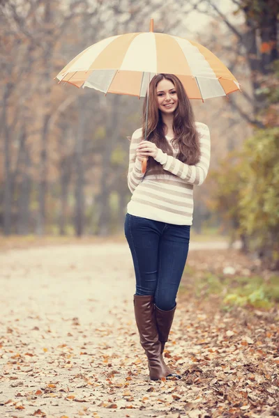 Bella ragazza con ombrello al parco autunnale . — Foto Stock