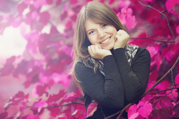 Beautiful girl at autumn park. Leafs in pink color. — Stock fotografie