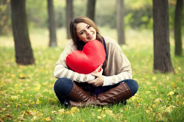 Redhead girl with toy heart at autumn park. — Stok fotoğraf