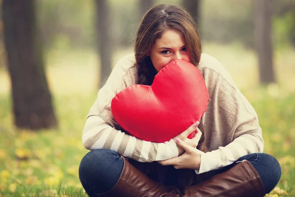 Redhead girl with toy heart at autumn park. — Stok fotoğraf