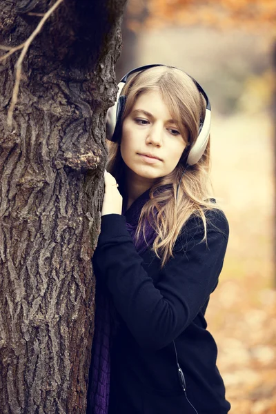 Portrait of girl with headphones at outdoor. Autumn. — Stock Photo, Image