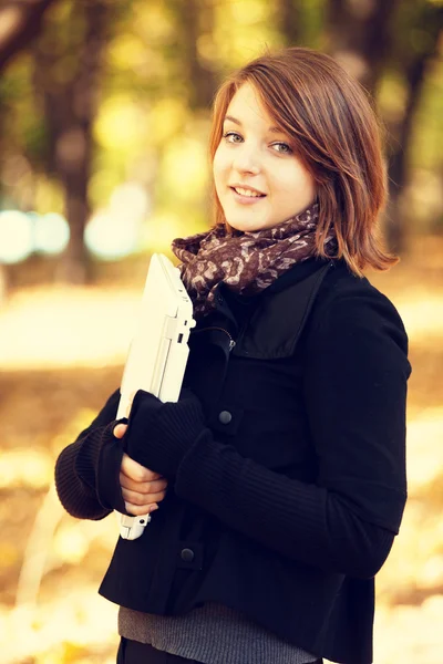 Portret roodharige meisje op met laptop buiten. herfst. — Stockfoto