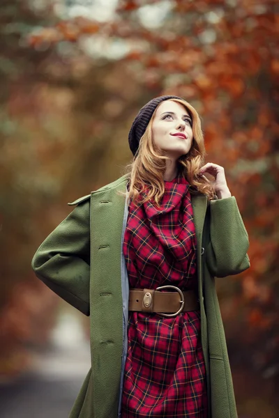 美しい秋の路地でスタイルの赤毛の女の子. — ストック写真